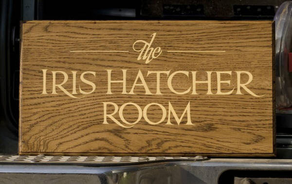 The Iris Hatcher Room, freehand Trajan lettering on oak.