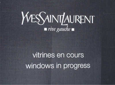Painted logo on charcoal grey open weave material (detail view) . Overall size to fit West End shop window. Painted logo on charcoal grey open weave material (detail view) . Overall size to fit West End shop window.